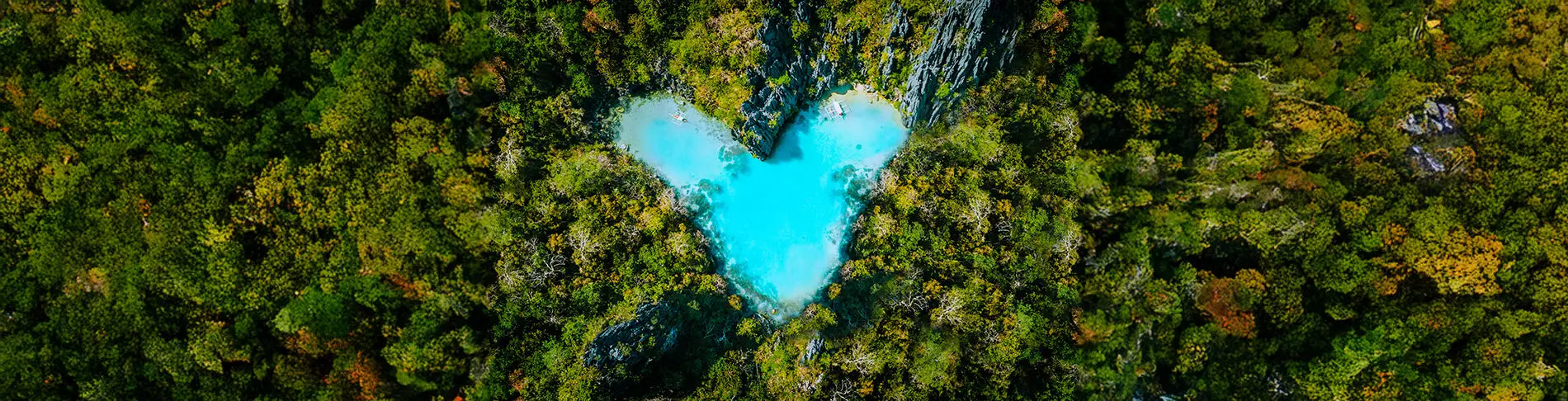 Aerial top view of turquoise lagoon shaped heart inside of tropical island. Love travel summer vacation