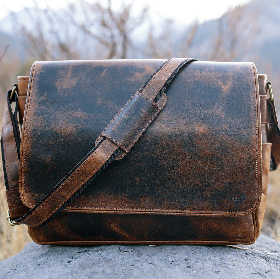 Brown leather satchel bag on a rock with a natural background