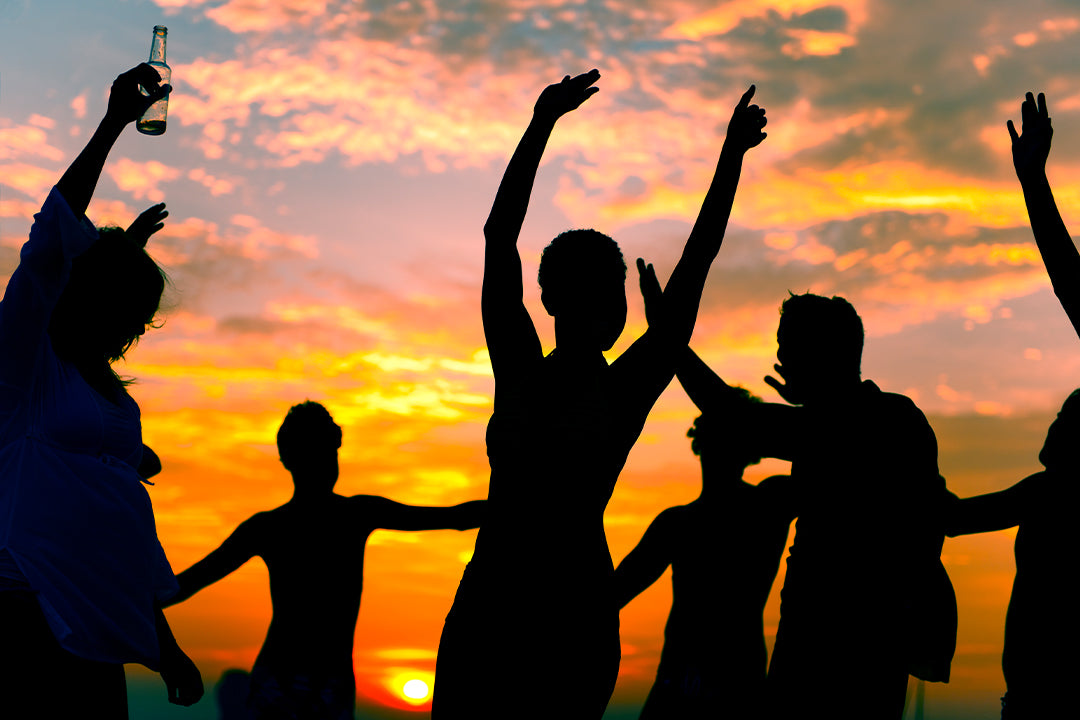 friends partying at the beach during sunset