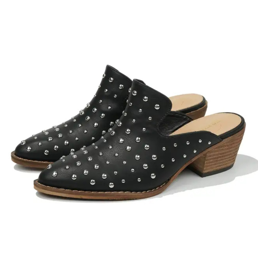 Black studded mules on a white background