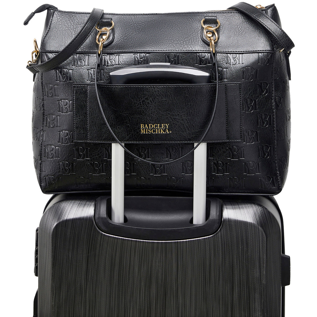 black vegan leather weekender bag on luggage trolley