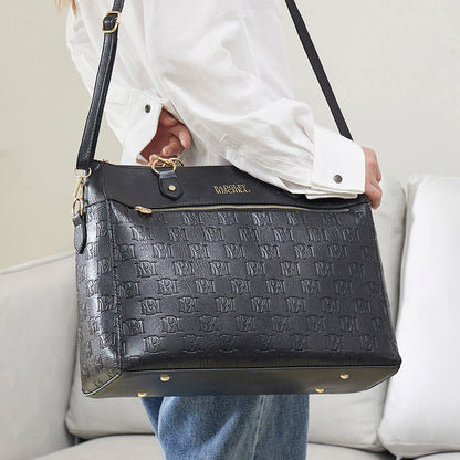 woman with black vegan leather weekender bag using the shoulder strap